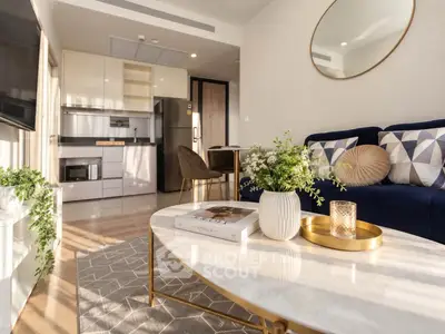 Modern living room with stylish decor and open kitchen layout, featuring elegant furniture and natural light.