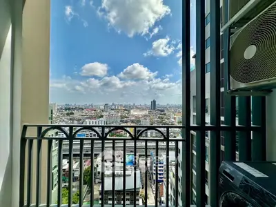 Stunning cityscape view from a high-rise balcony with clear blue skies.
