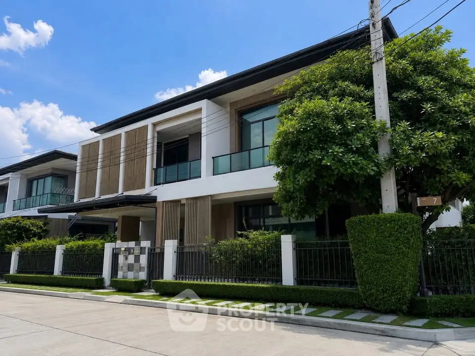 Modern luxury townhouse with sleek design and lush greenery in a serene neighborhood.