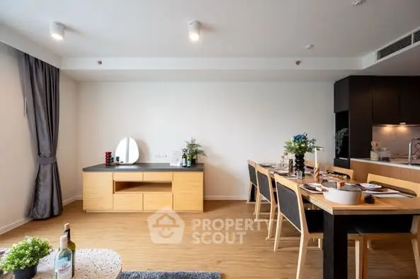 Modern dining area with sleek furniture and open kitchen layout in stylish apartment.