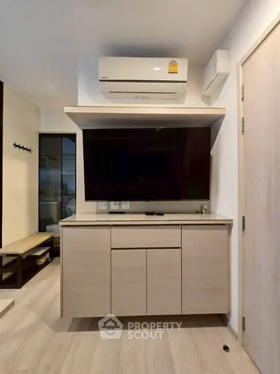 Modern living room with sleek TV cabinet and air conditioning unit, perfect for comfortable living.