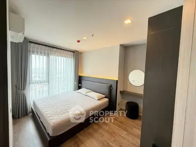 Modern bedroom with large window and stylish decor in a high-rise apartment.