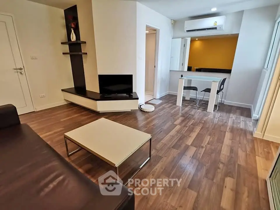 Modern living room with sleek furniture and wooden flooring in a stylish apartment.