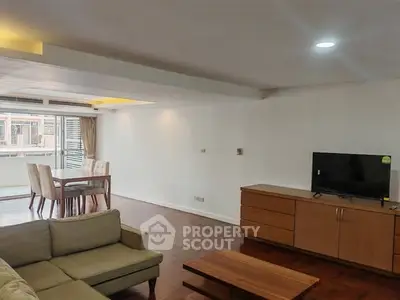 Spacious living room with modern furniture and dining area, featuring large windows for natural light.