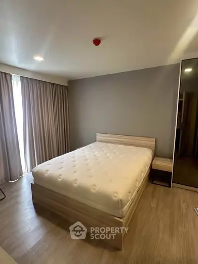 Spacious bedroom with modern design and natural light in a stylish apartment.