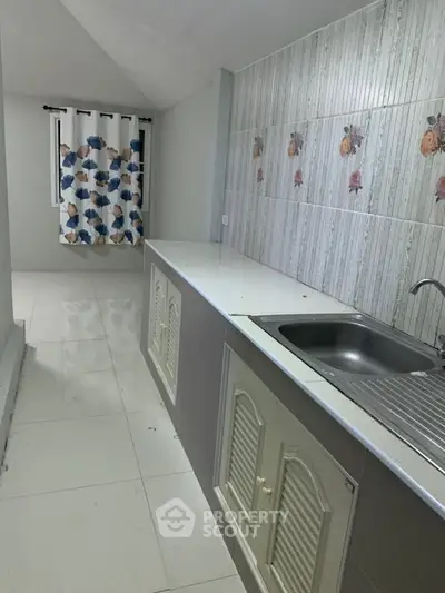 Modern kitchen with sleek countertops and floral tile backsplash