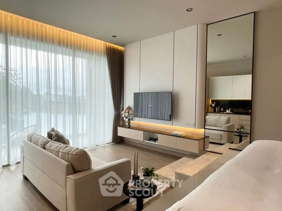 Luxurious modern living room with elegant decor and large windows offering natural light.