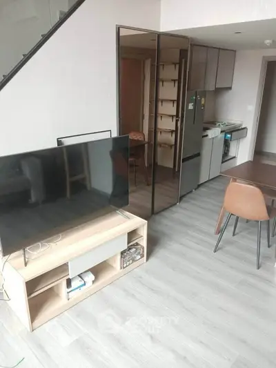 Modern open-plan living room with sleek kitchen and stylish furniture in a contemporary apartment.