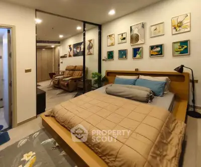 Modern bedroom with stylish decor and open layout leading to a cozy living area.