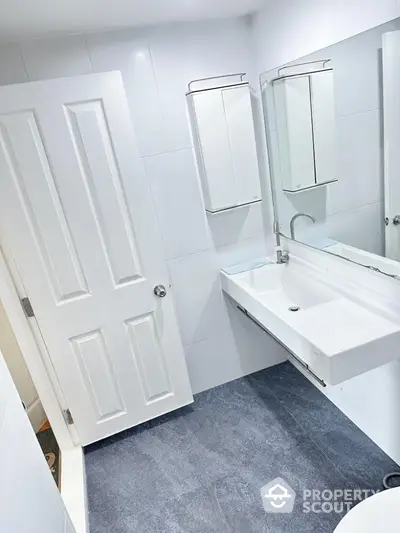 Modern white bathroom with sleek fixtures and large mirror