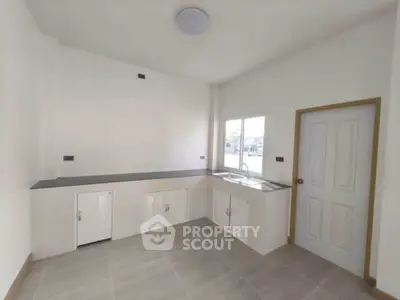 Spacious modern kitchen with sleek countertops and ample storage space.