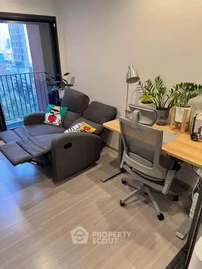 Modern study area with ergonomic chair, desk, and cozy recliner near balcony view.