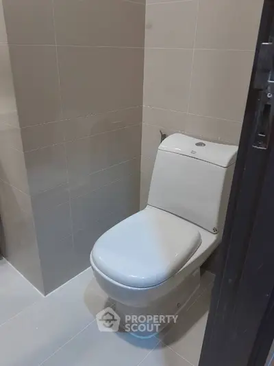 Modern bathroom with sleek toilet design and neutral tile decor