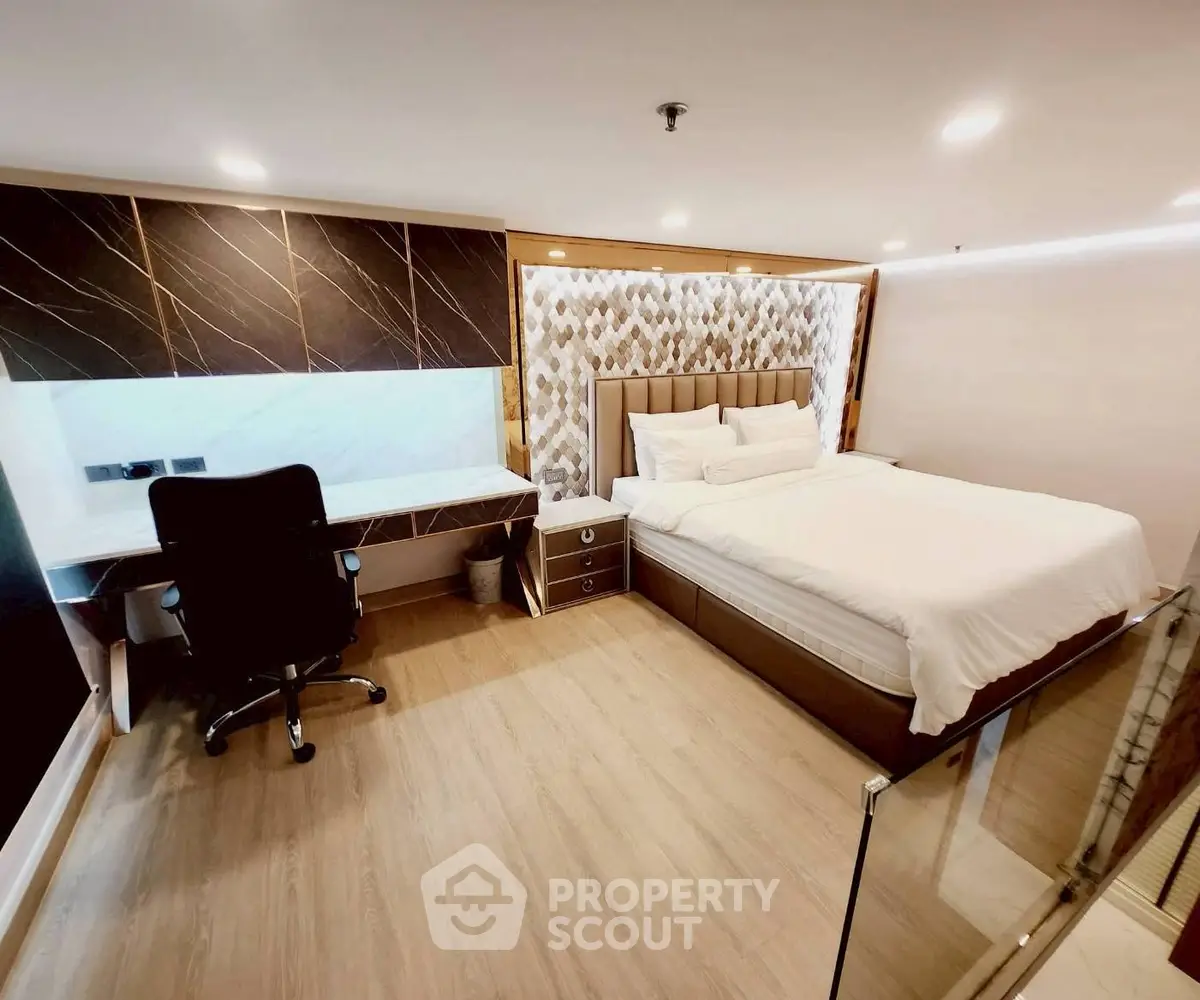 Luxurious bedroom with modern decor and study area, featuring elegant lighting and stylish furnishings.