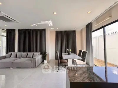 Spacious modern living room with elegant dining area and large windows for natural light.