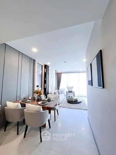 Elegant modern living room with dining area, featuring stylish decor and ample natural light.