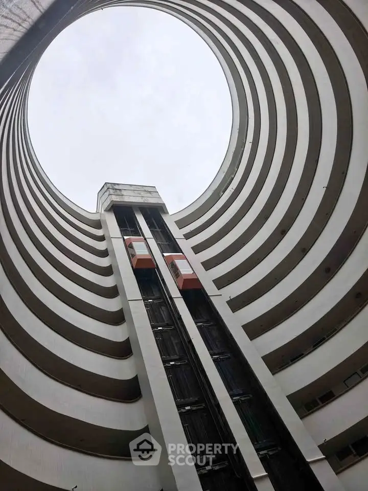 Stunning architectural view of a modern high-rise building with unique circular design and glass elevators.