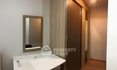 Modern bedroom with sleek wooden wardrobe and minimalist dressing table.