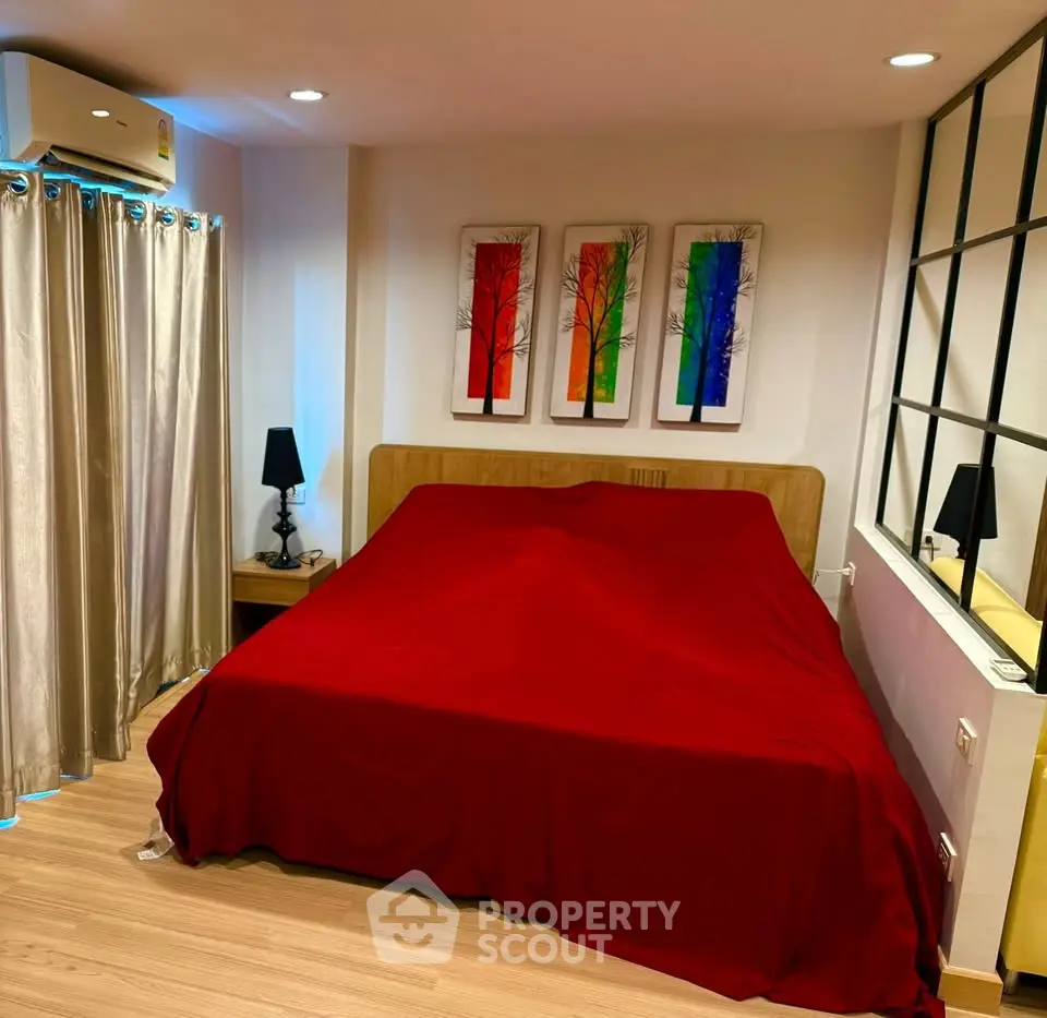 Cozy bedroom with modern decor and vibrant artwork above bed