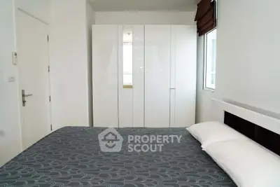 Modern bedroom with sleek white wardrobe and stylish bedding