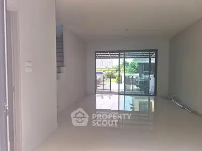 Spacious interior with large glass doors opening to a garden view, perfect for modern living.