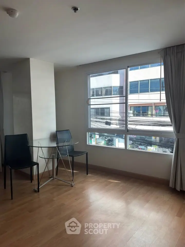 Bright corner unit with large windows and modern dining area in city apartment.