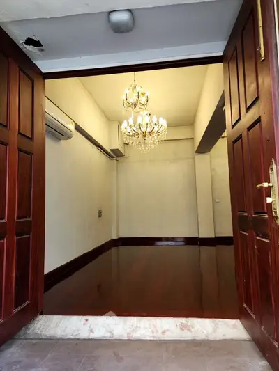Elegant entrance with chandelier and polished wooden floors in a luxurious property.