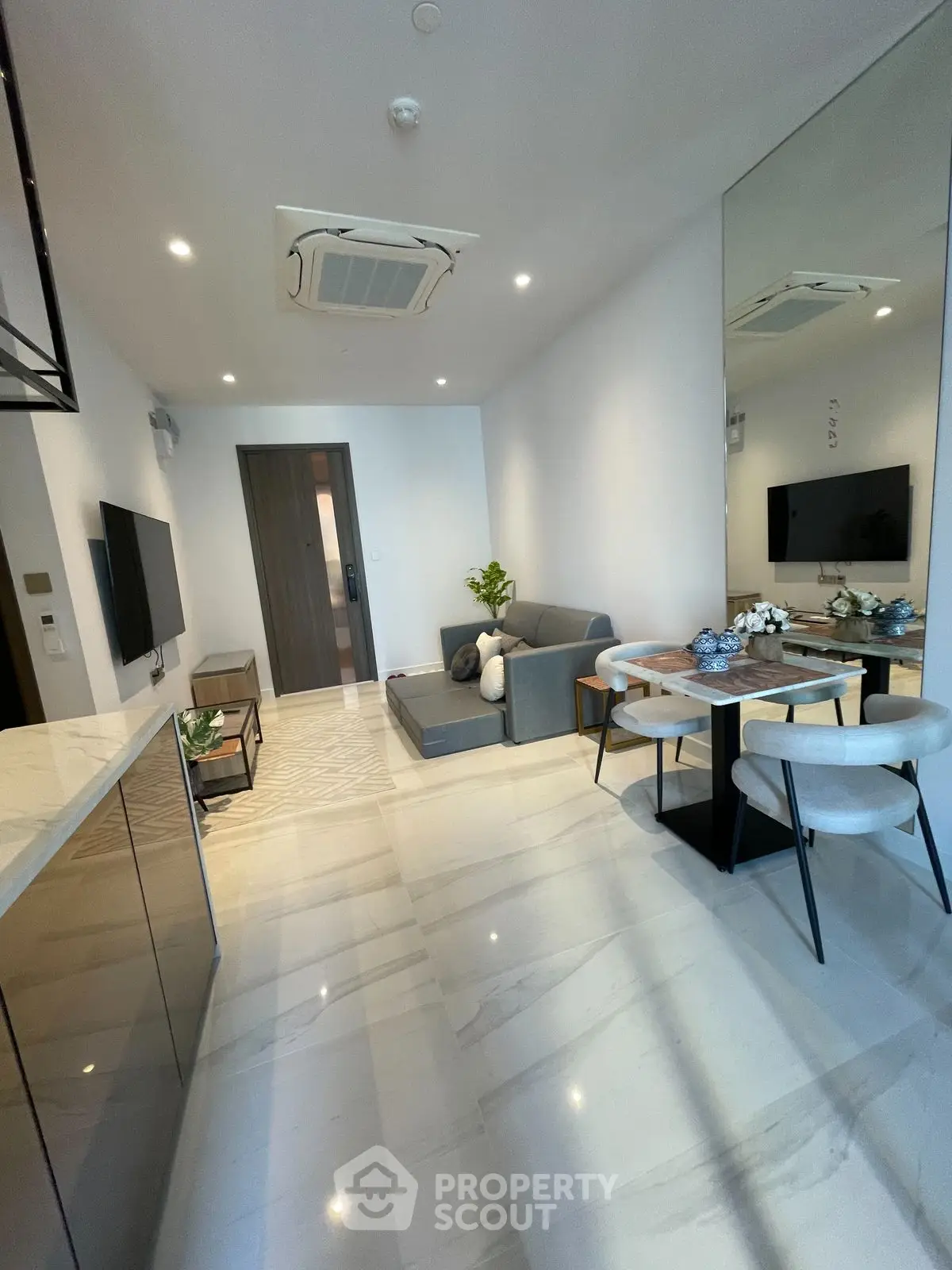 Modern living room with sleek furniture and elegant dining area, featuring a minimalist design and bright lighting.