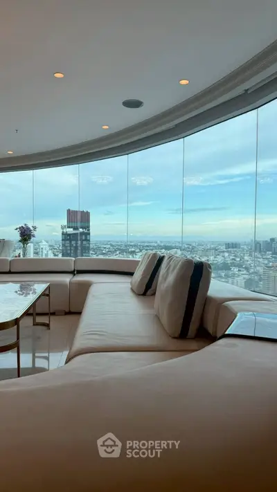 Luxurious living room with panoramic city view and elegant curved sofa.