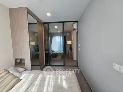 Modern bedroom with glass partition and stylish decor in a contemporary apartment.