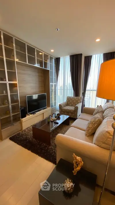 Elegant living room with modern decor, large windows, and cozy seating area.