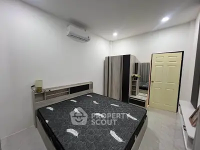 Modern bedroom with stylish furniture and air conditioning, featuring a comfortable bed and sleek wardrobe.