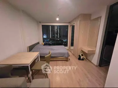 Modern studio apartment with cozy bedroom and city view, featuring stylish wooden furniture and large window.