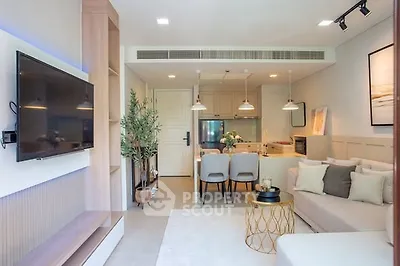 Modern open-plan living room with stylish decor and kitchen area