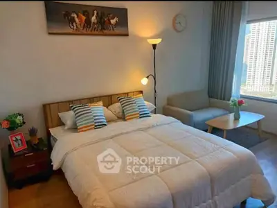 Cozy bedroom with modern decor and city view, featuring a comfortable bed and stylish furnishings.