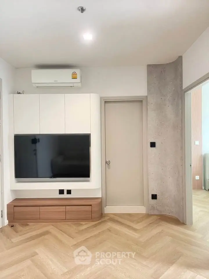 Modern living room with sleek TV unit and stylish herringbone flooring