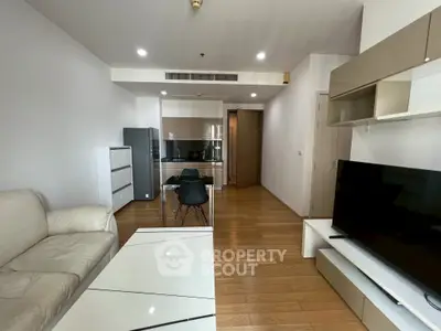 Modern living room with sleek furniture and open kitchen layout in a stylish apartment.