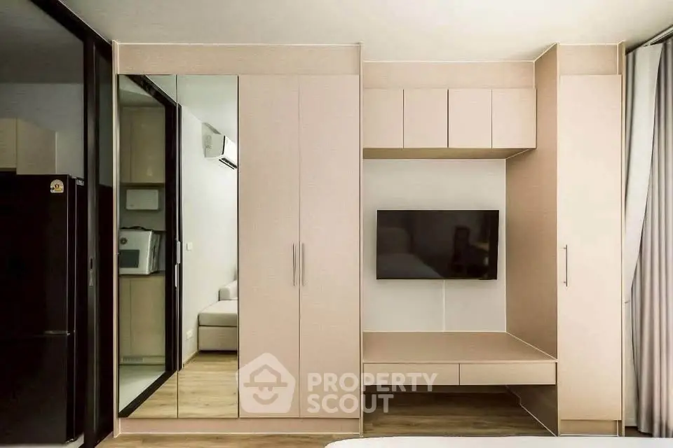 Modern living room with built-in storage and wall-mounted TV in a stylish apartment.