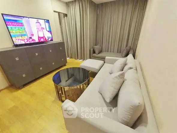 Modern living room with sleek furniture and large TV, perfect for relaxation.