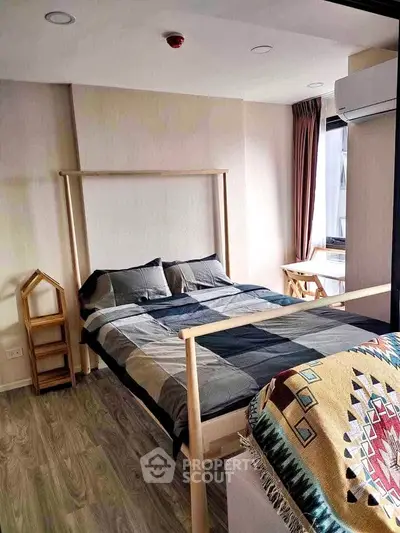 Modern bedroom with stylish decor and natural light, featuring a cozy bed and wooden flooring.