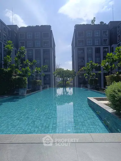 Luxurious modern apartment complex with stunning pool and lush greenery