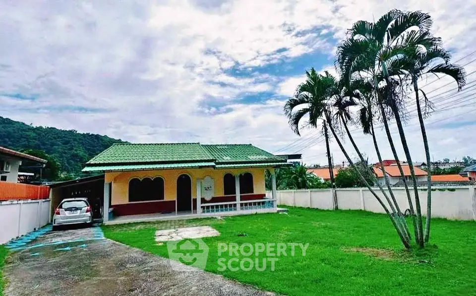 Charming single-story home with green roof and spacious lawn in a serene neighborhood.