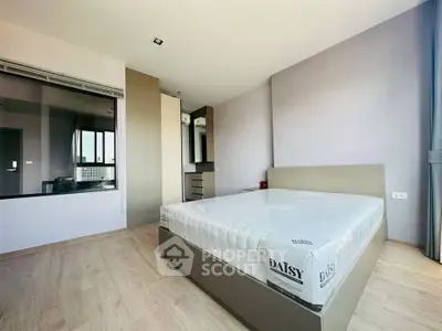 Modern bedroom with minimalist design and large window for natural light.