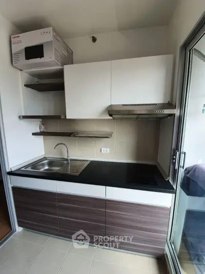 Modern compact kitchen with sleek cabinets and built-in appliances