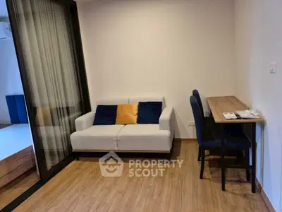 Cozy living room with modern sofa and workspace, perfect for relaxation and productivity.