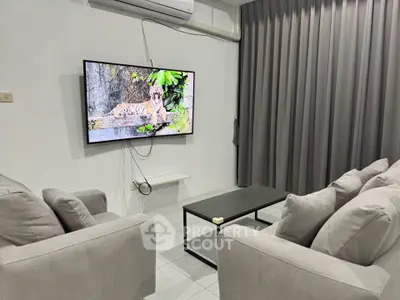 Modern living room with sleek furniture and wall-mounted TV, perfect for relaxation and entertainment.