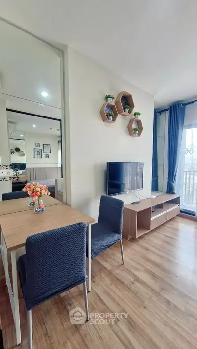 Modern living room with stylish decor, wooden flooring, and natural light from large windows.