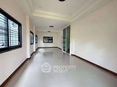 Spacious empty room with large windows and glossy floor tiles