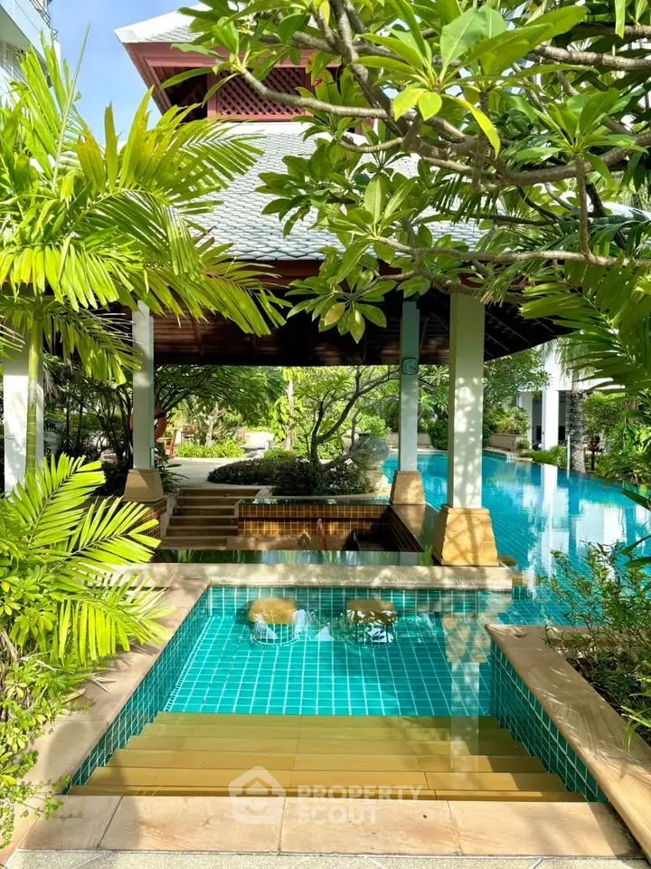 Luxurious tropical poolside retreat with lush greenery and serene ambiance.