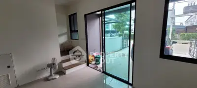 Modern home entrance with sleek glass door and steps leading to upper level